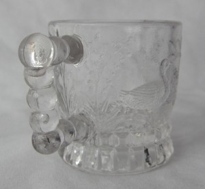 Swan - aka Water Fowl, U.S. Glass No. 3802, or Federal's No. 3802 (Size: 1-7/8" dia. x 2" ht.; Color: Clear) To the right of the handle, sculpting shows a swimming duck among water grasses.